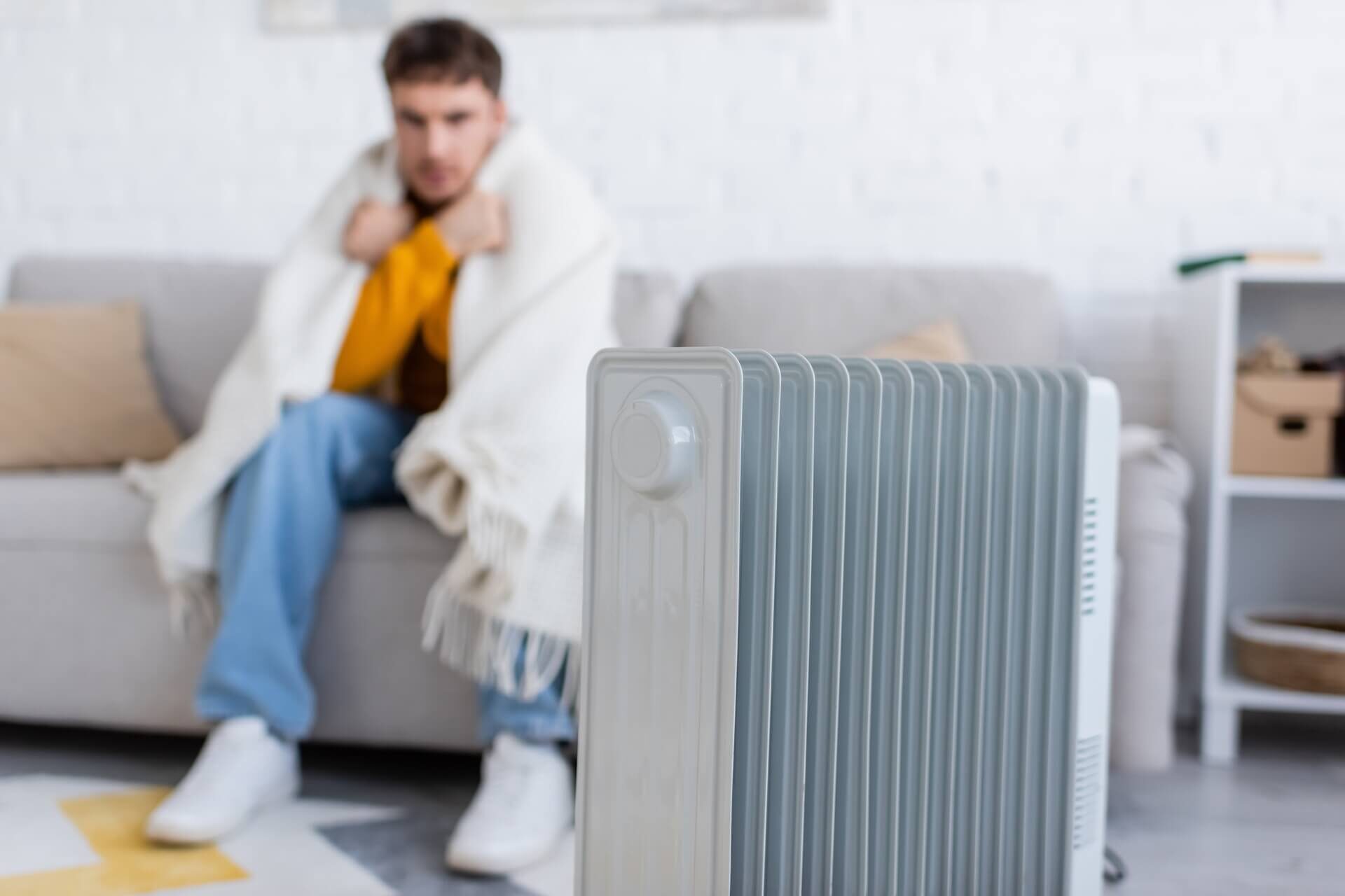 Man sitting with blanket due to home furnace not working