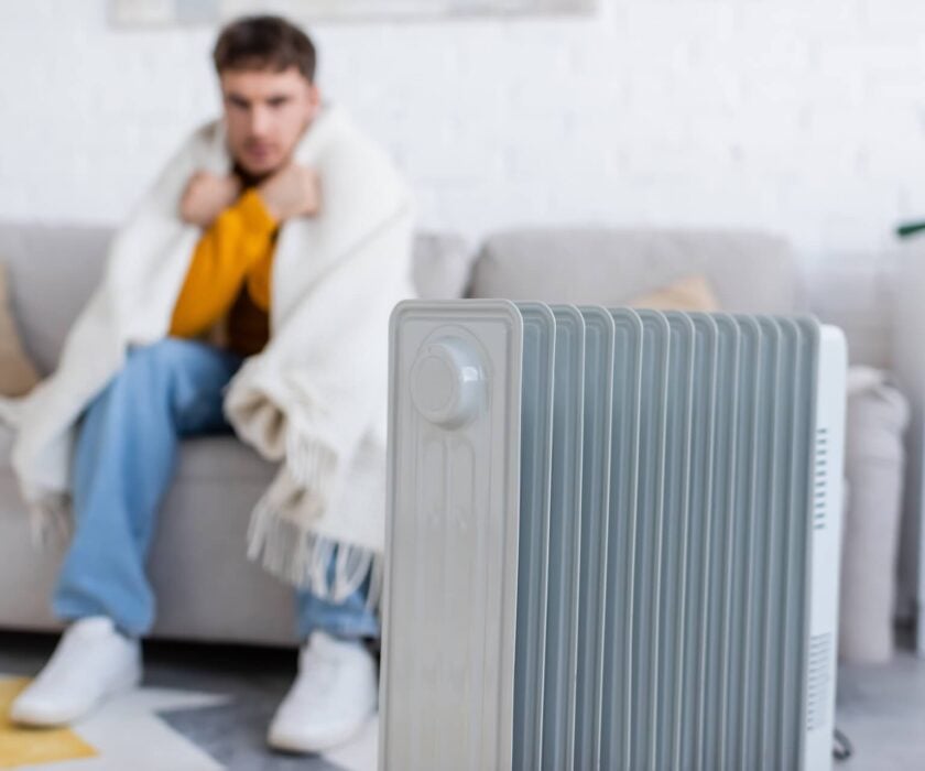 Man sitting with blanket due to home furnace not working